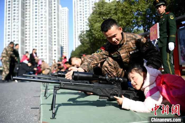 孩子们在武警叔叔的指导下有序体验武器装备。　韩苏原 摄