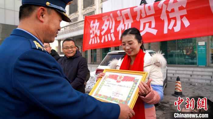 图为西藏军区派出的“小分队”负责人把奖状送到徐飞龙的家属手中。　高鹏飞 摄