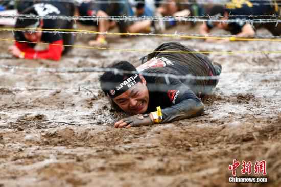 资料图：斯巴达勇士赛(Spartan Race)北京站开赛，本站全程6公里，设有俄尔普斯之禁、胜利之矛、人猿泰山、海格力斯之臂等21个障碍供勇士挑战，吸引了3000名中外长跑、障碍跑及健身爱好者参与其中，中国短跑名将张培萌及前体操世界冠军陈一冰一同参加挑战。 /p中新社记者 富田 摄