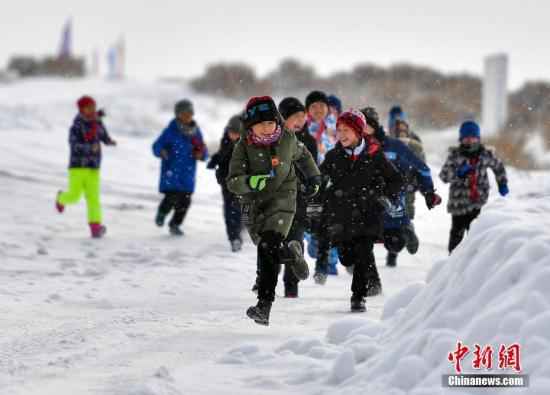 资料图：2019年1月3日，新疆福海县乌伦古湖旁的一处冰雪体验场地，60余名小学生在零下20℃左右的低温环境中上体育课。/p中新社记者 刘新 摄