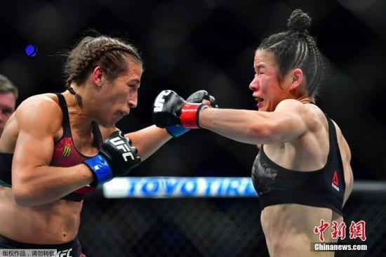 北京时间3月8日，中国首位UFC冠军张伟丽在美国拉斯韦加斯举行的UFC248站女子草量级世界冠军卫冕战上，在五个回合里以点胜击败波兰选手乔安娜，成功卫冕。去年8月，张伟丽在深圳用时不到1分钟就KO了现役王者安德拉德，创造了中国格斗历史。图为张伟丽(右)在卫冕战比赛中。 