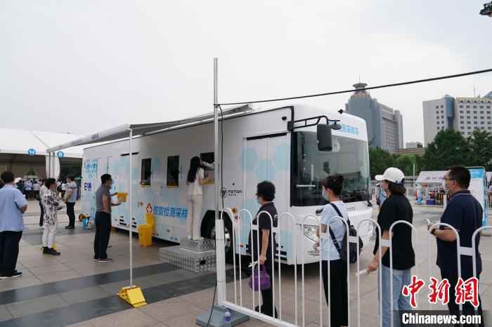 6月28日，北京市民在核酸检测采样车前参加检测。　苏丹 摄