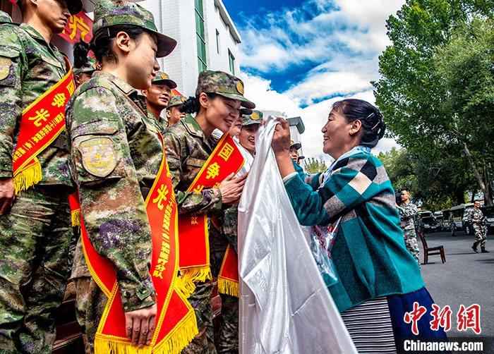 中国人民解放军西藏军区9月12日透露，9月10日，西藏军区在拉萨举行赴刚果(金)维和医疗分队出征仪式。在维和官兵亲属的见证下，雪域高原首支由43名医疗卫生方面官兵组成的分队经过2个月的准备后，将于9月14日启程前往刚果(金)，加入第24批赴刚果(金)维和部队，这也是西藏军区首次抽组力量参加国际维和任务。图为9月10日，西藏拉萨，出征队员家属前来送别，并为队员们献上哈达，祝福队员们平安归来。
/p中新社发 张钊 摄